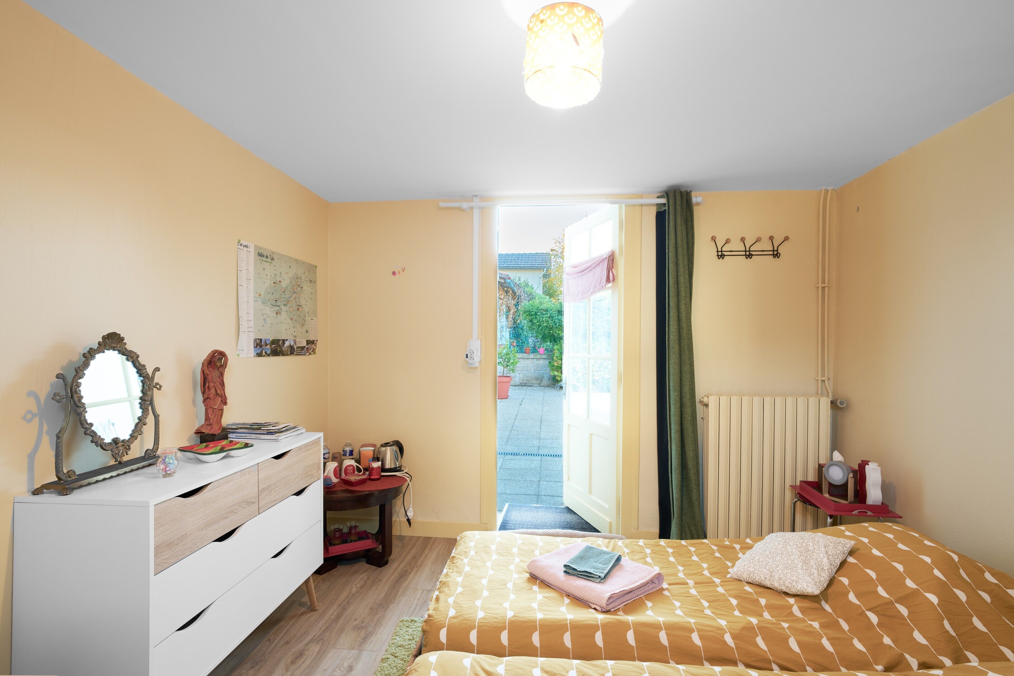 Un dormitorio con cama, cómoda y vistas al exterior.