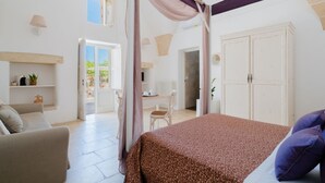 A bedroom with a bed, a chair, a wardrobe, and a desk.