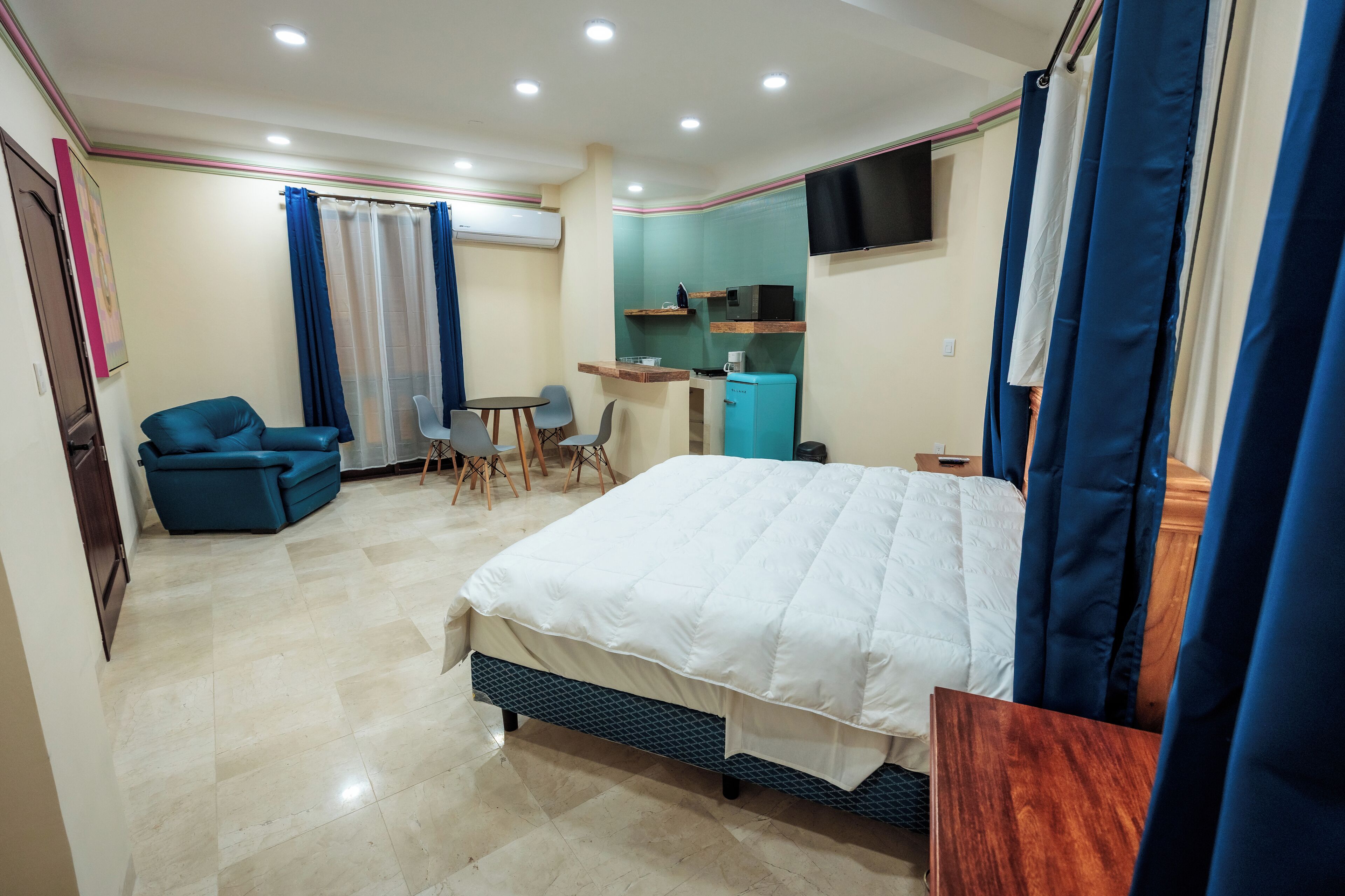 Une chambre d’hôtel équipée d’un lit, d’un bureau, d’une chaise, d’un canapé et d’une télévision.