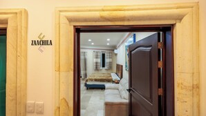 Un pasillo que conduce a un dormitorio con una cama, un sofá y un letrero en la pared que dice 'ZAACHILA'.