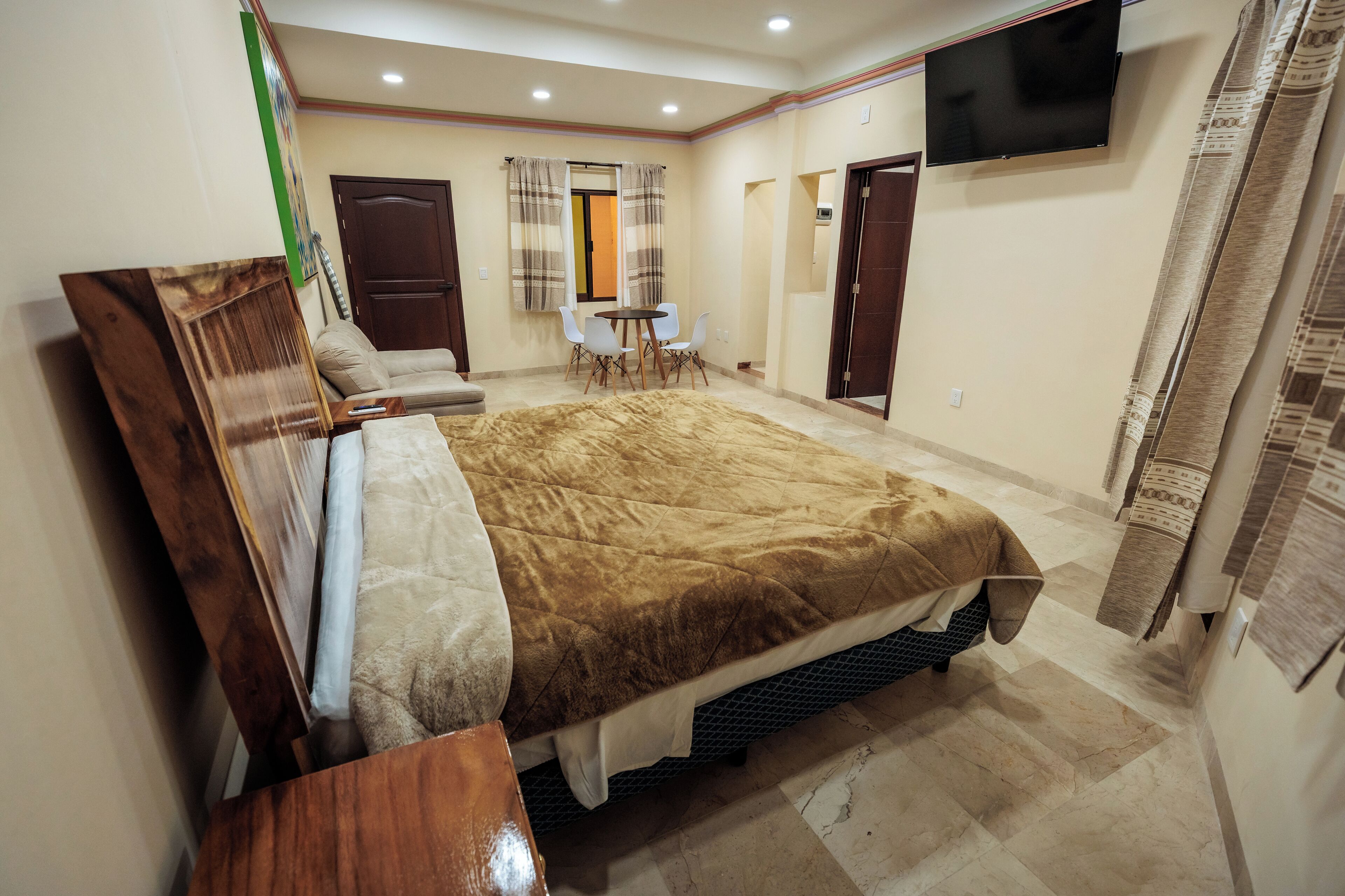 Una camera da letto con un letto, una scrivania e una televisione.
