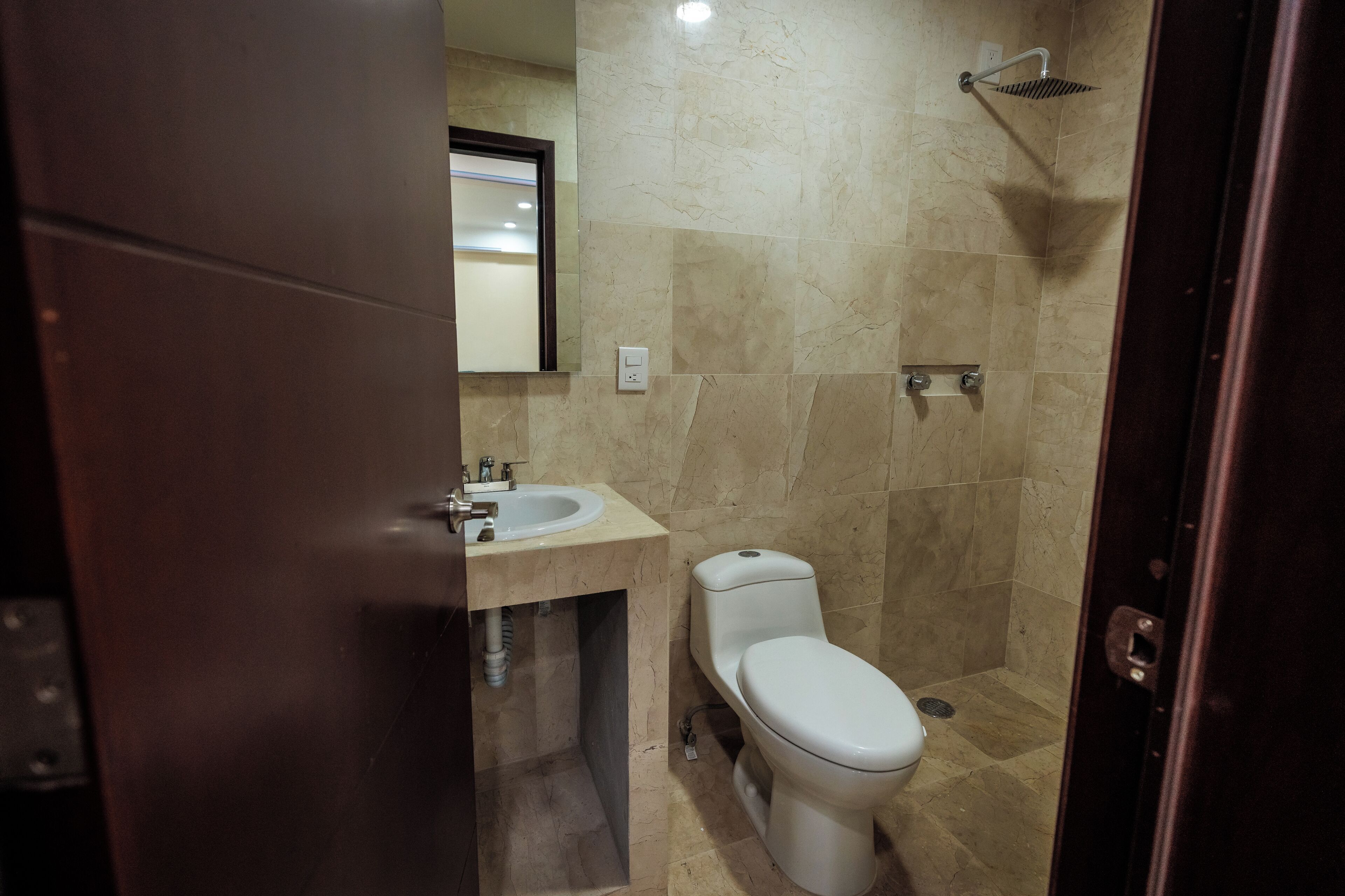 A bathroom with a toilet, sink, and shower.