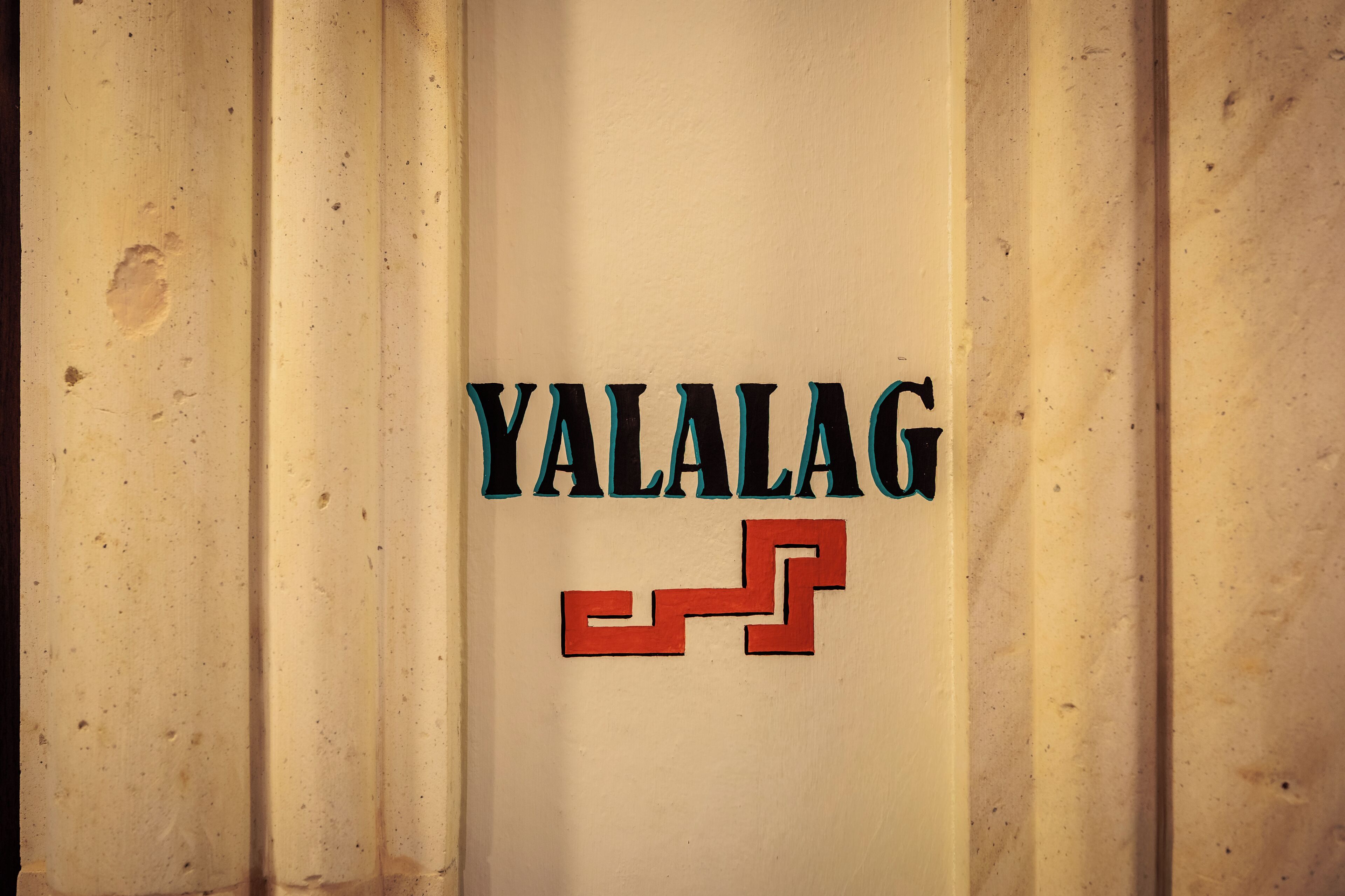 A sign with the text "YALALAG" and a geometric design.