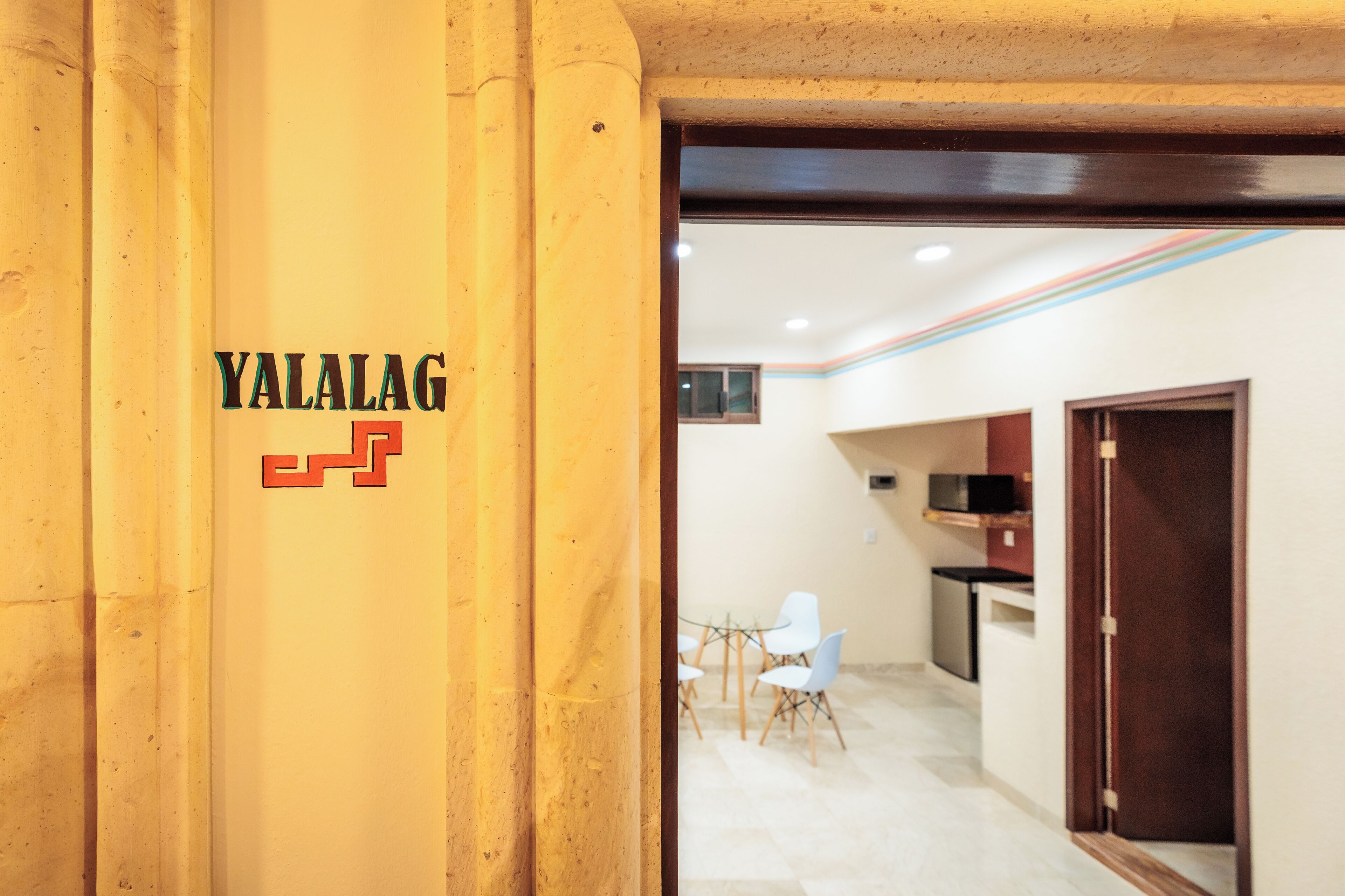 A reception area with a wooden pillar displaying the name 'YALALAG'.