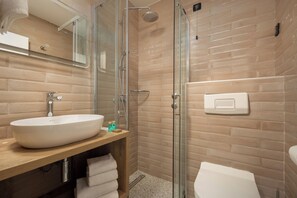 A modern bathroom with a large white sink, a glass shower enclosure, and a toilet. - Hotel Delfin (Omišalj)