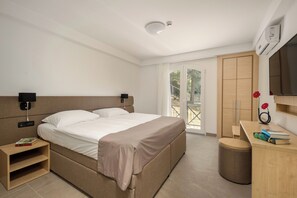 A modern bedroom with a large bed, bedside tables, a desk, and a wardrobe. - Hotel Delfin (Omišalj)