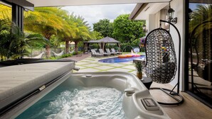 A hot tub with a tiled patio area, lounge chairs, and a small pool. - Private Resort Stay - Insta-Worthy Miami Vacation (Miami)