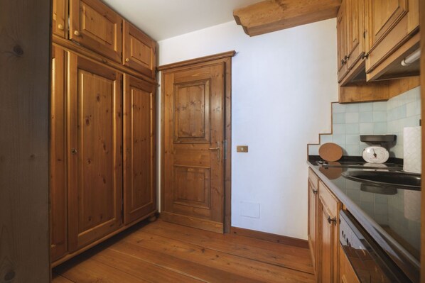 A kitchen with wooden cabinets, a door, a countertop, and a sink.