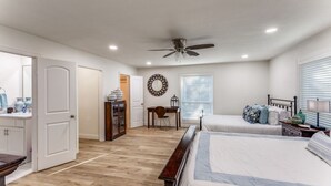 A bedroom with two beds, a ceiling fan, a desk, and a window with blinds. - Charming house in Fort Worth walking distance to TCU (Fort Worth)