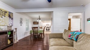 A living room with a sofa, a dining area with a table and chairs, and a kitchen in the background. - Charming house in Fort Worth walking distance to TCU (Fort Worth)