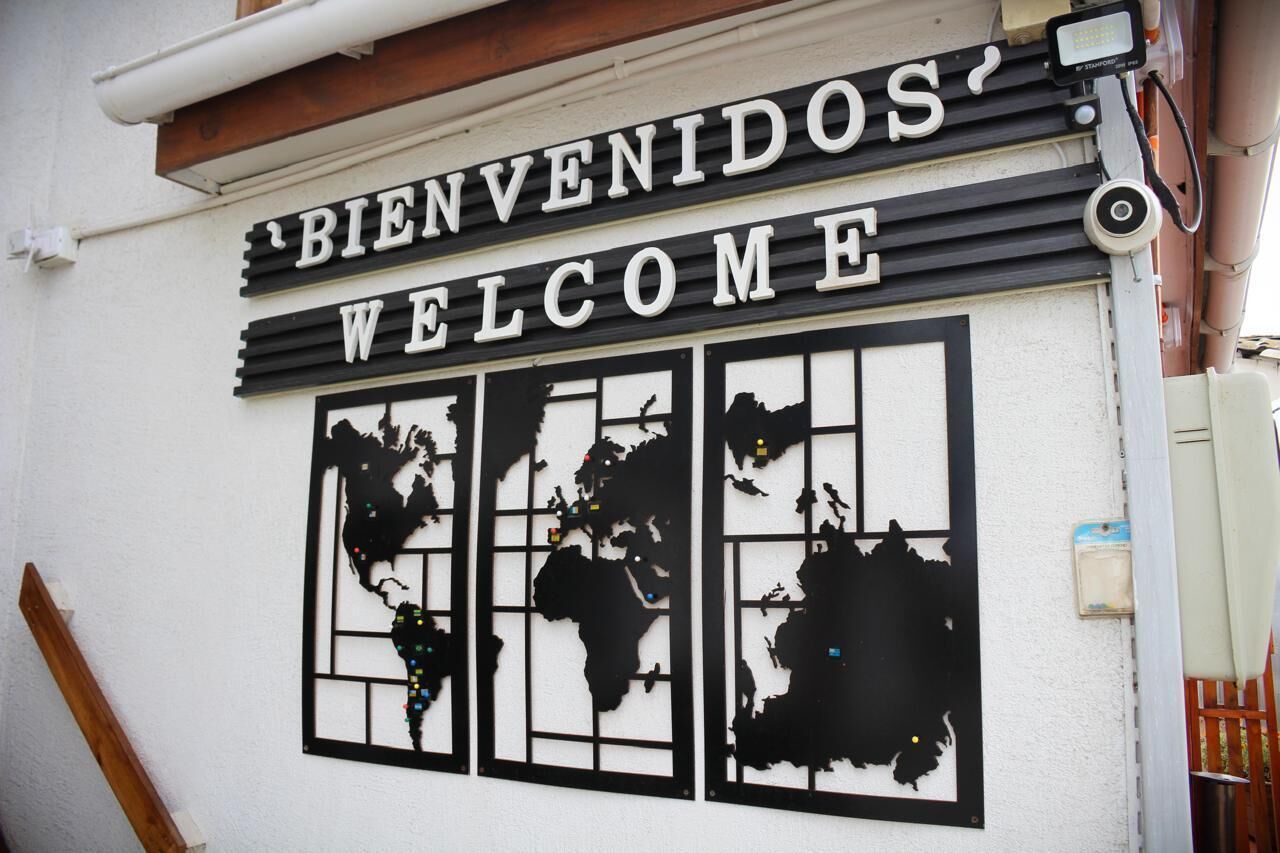A 'BIENVENIDOS' welcome sign with a world map design.
