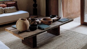 A room with a wooden bench, a hanging light fixture, a sofa, and a view of greenery outside. - Villa Najil Chak Tulum : 16 Guests : Private Pool : Groups Retreats & Events (Tulum)