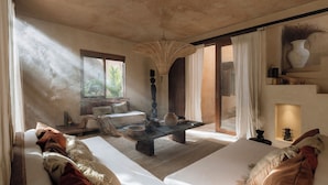 A spacious room with a large window, a woven ceiling light, a sofa, a coffee table, and a decorative vase. - Villa Najil Chak Tulum : 16 Guests : Private Pool : Groups Retreats & Events (Tulum)