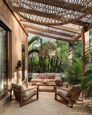 An outdoor seating area with a woven ceiling, a sofa, and chairs. - Villa Najil Chak Tulum : 16 Guests : Private Pool : Groups Retreats & Events (Tulum)