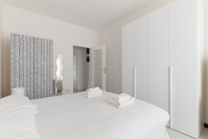 2 dormitorios y tabla de planchar con plancha