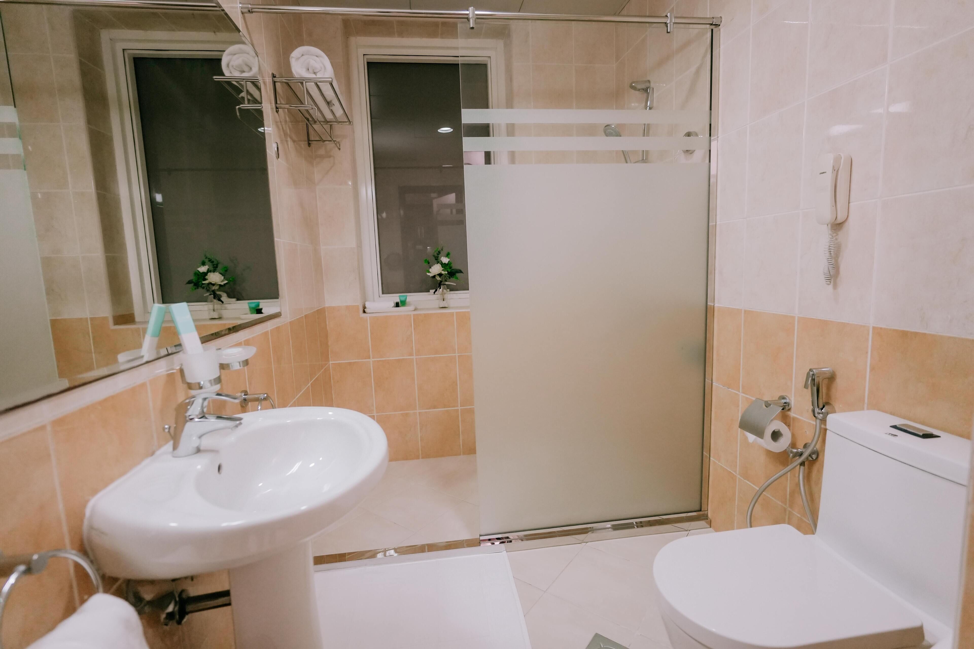 Une salle de bain avec un lavabo, des toilettes et une douche.