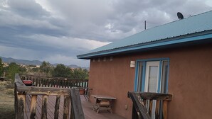 En byggnad med ett blått tak och en träveranda som leder fram till en dörr.