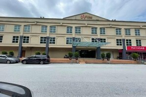 Un hôtel avec une entrée centrale, une galerie couverte et une enseigne indiquant « MAYSAB ».
