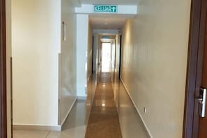 Un pasillo largo y estrecho con un letrero que indica la dirección a la recepción.