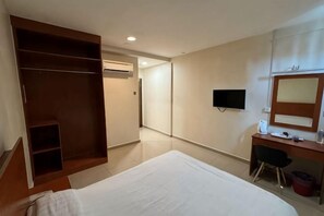 A hotel room with a bed, a desk, a wardrobe, a television, and an air conditioning unit. - Aeton Hotel Nilai (Nilai)