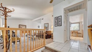 A spacious living area with a wooden staircase, a dining area, and a view of the outside through a window. - Spacious 4 bedroom with 7 beds! (Las Vegas)