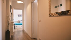 A hallway with a bed in the background, a radiator, and a wall-mounted sign. - MILANO 71 (Milan)