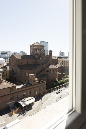 A historic building with a bell tower and a modern glass structure nearby.
