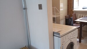 A laundry area with a washing machine, a drying rack, and a bench. - Perfect for Old Town, Chopin and Warsaw Universities Visits. Safe, quiet, budget (Warszawa)