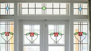 A white door with four stained glass windows featuring floral designs. - Orby Cottage (Skegness)