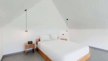 Un dormitorio con una cama individual, una mesita de noche y dos lámparas colgantes.