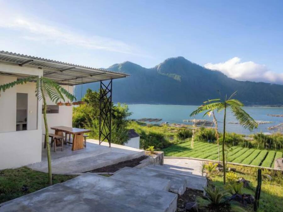 Una casa con patio que da a un lago y montañas.