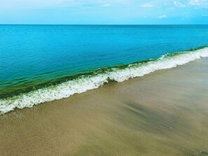 A beach with clear turquoise water and a sandy shore.