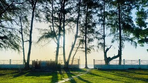 A pathway leading to a gate with a fence and trees. - Leelavadee Villa Sea Views (Tha Sala)