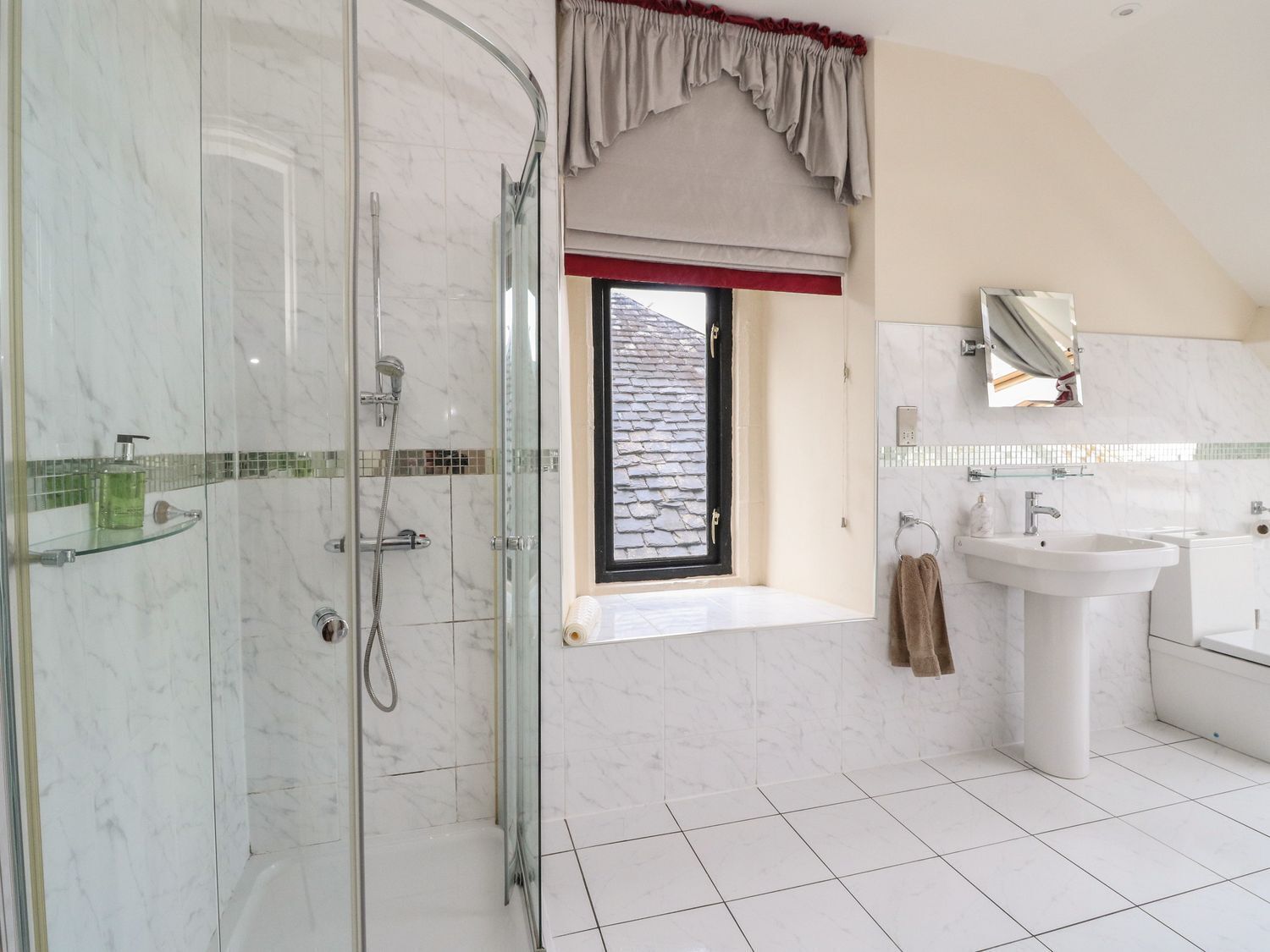 Une salle de bain moderne avec une douche à parois de verre, une grande fenêtre offrant une belle vue, un lavabo et une baignoire.