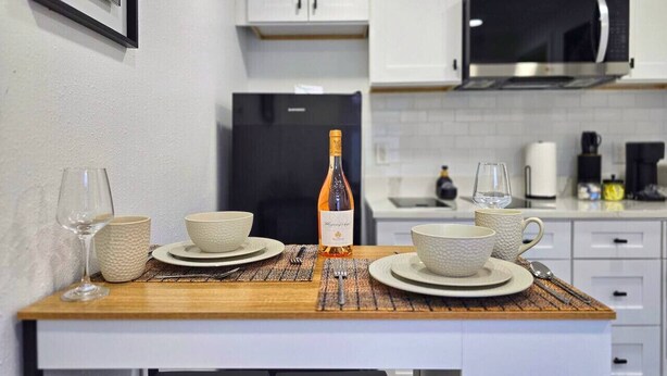 A compact kitchen with white cabinets, a microwave, and a refrigerator. - Right Apt 1 BR, 7` TPA Airport, 14` Ray Jam, Pkng (Tampa)