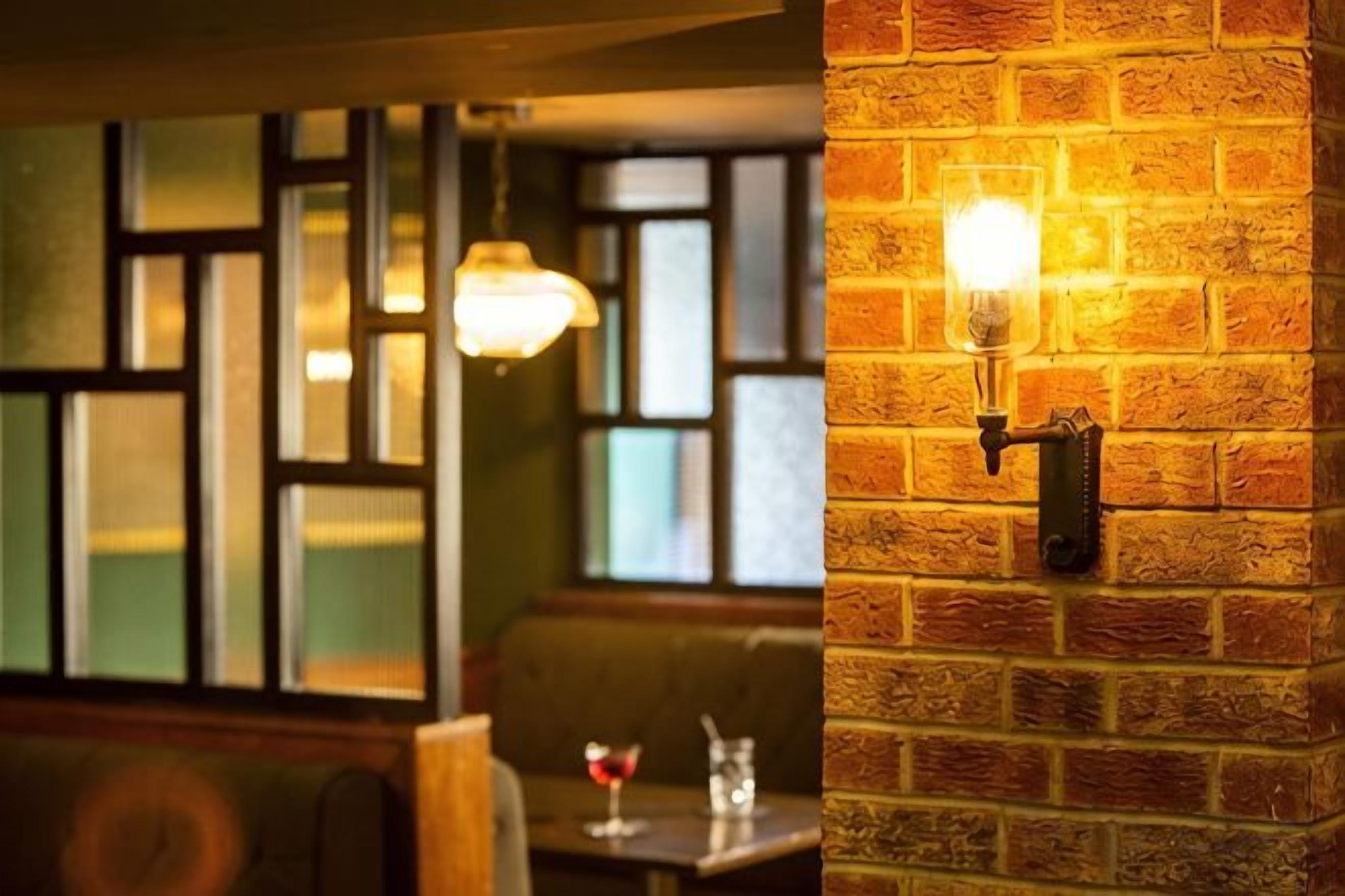 A brick wall with a wall-mounted light fixture.