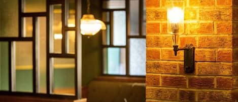 A brick wall with a wall-mounted light fixture.