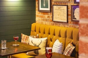 A cozy seating area with a wooden table, a cushioned bench, and a menu on the wall. - Bruntsfield Hotel, WorldHotels Elite (Edinburgh)