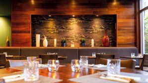 A restaurant with wooden walls, a stone wall centerpiece, and tables set with glasses and napkins. - Bruntsfield Hotel, WorldHotels Elite (Edinburgh)