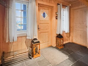 A wooden interior with a door, two lanterns, a drying rack, and a rug. - Mountain Cabin in Aurdal  Fireplace  Sauna 1000m (Nord-Aurdal)