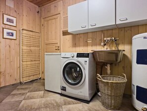 A laundry room with a front-loading washing machine, a drying rack, a wicker basket, and a water heater. - Mountain Cabin in Aurdal  Fireplace  Sauna 1000m (Nord-Aurdal)