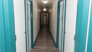 Un couloir avec des portes de couleur turquoise et un plancher en bois.