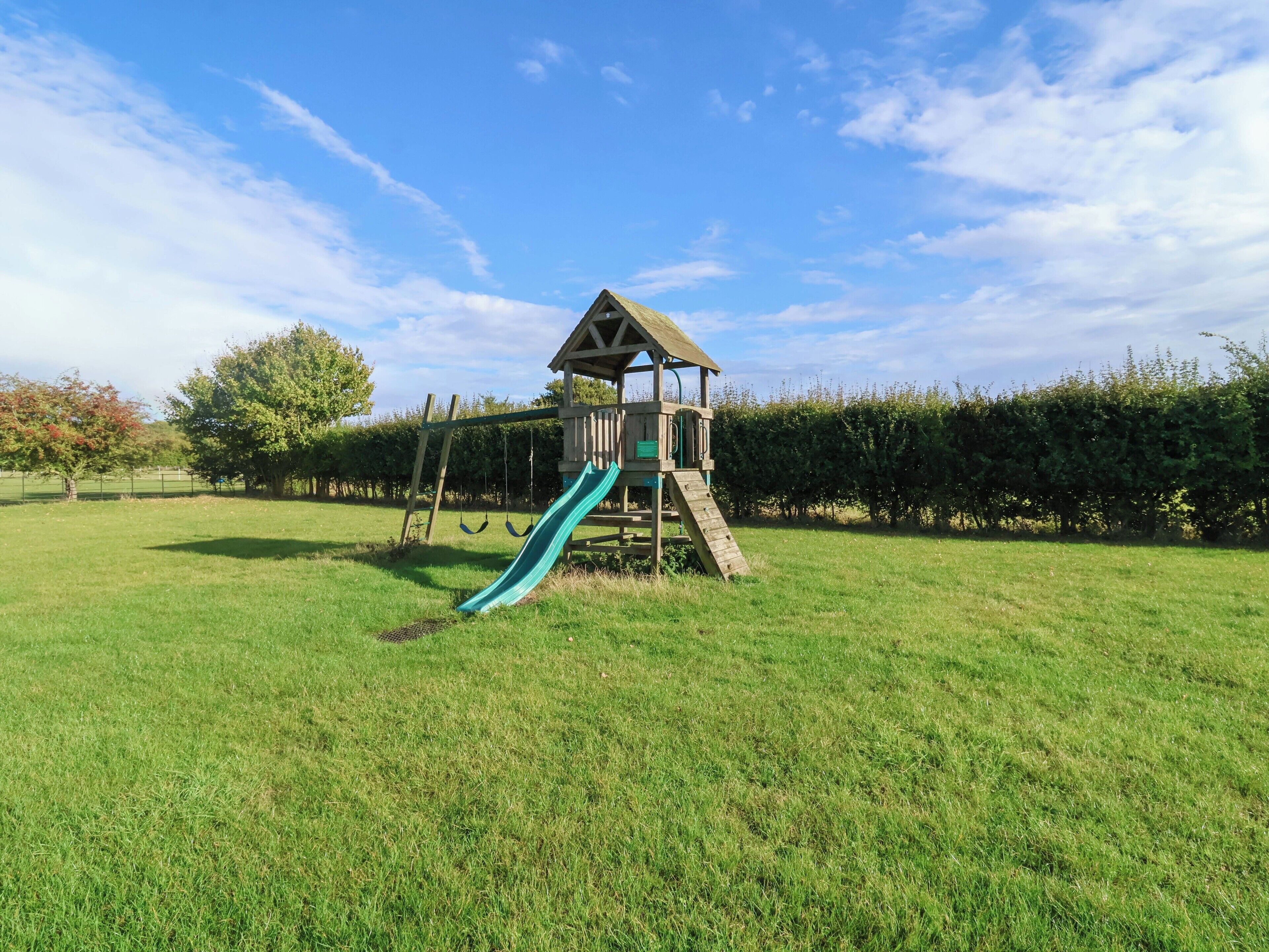Un parque infantil con tobogán y columpios.