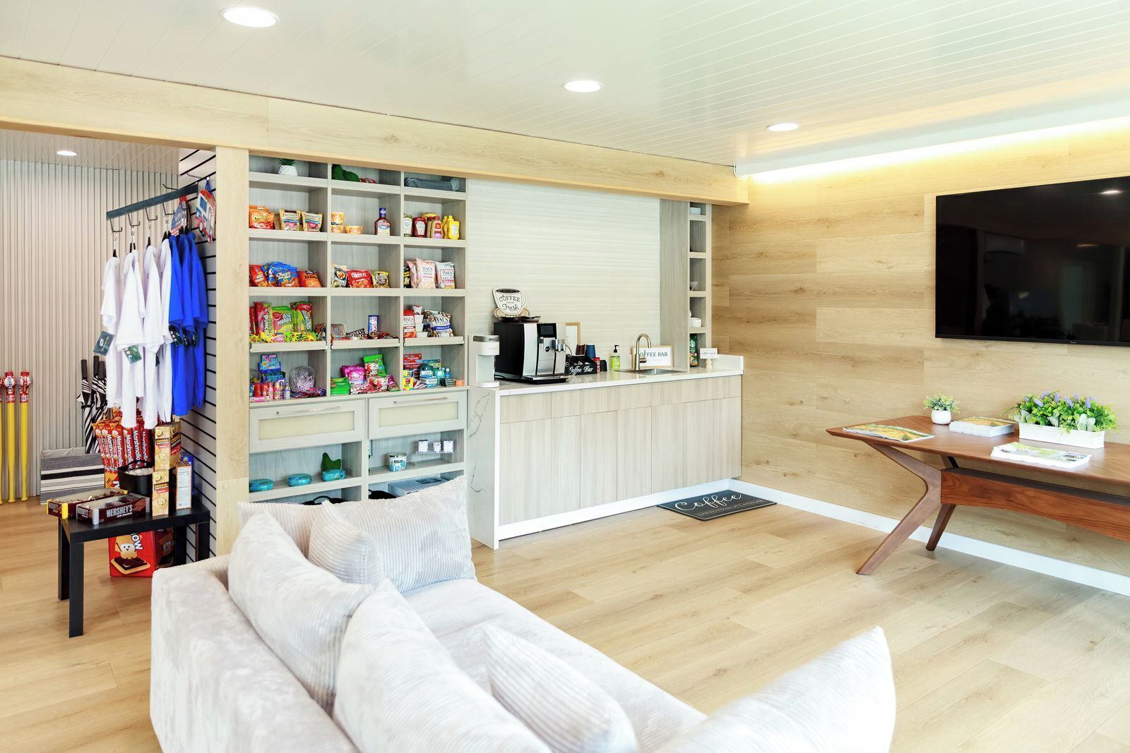 A modern living room with a sofa, a coffee bar, and a TV.