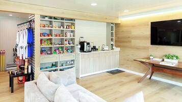 A modern living room with a sofa, a coffee bar, and a TV.