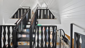 A staircase with black railings and a view of the outdoor area below. - Lake house views, w/dock in quiet cove, new renovations & great outdoors spaces! (Dahlonega)
