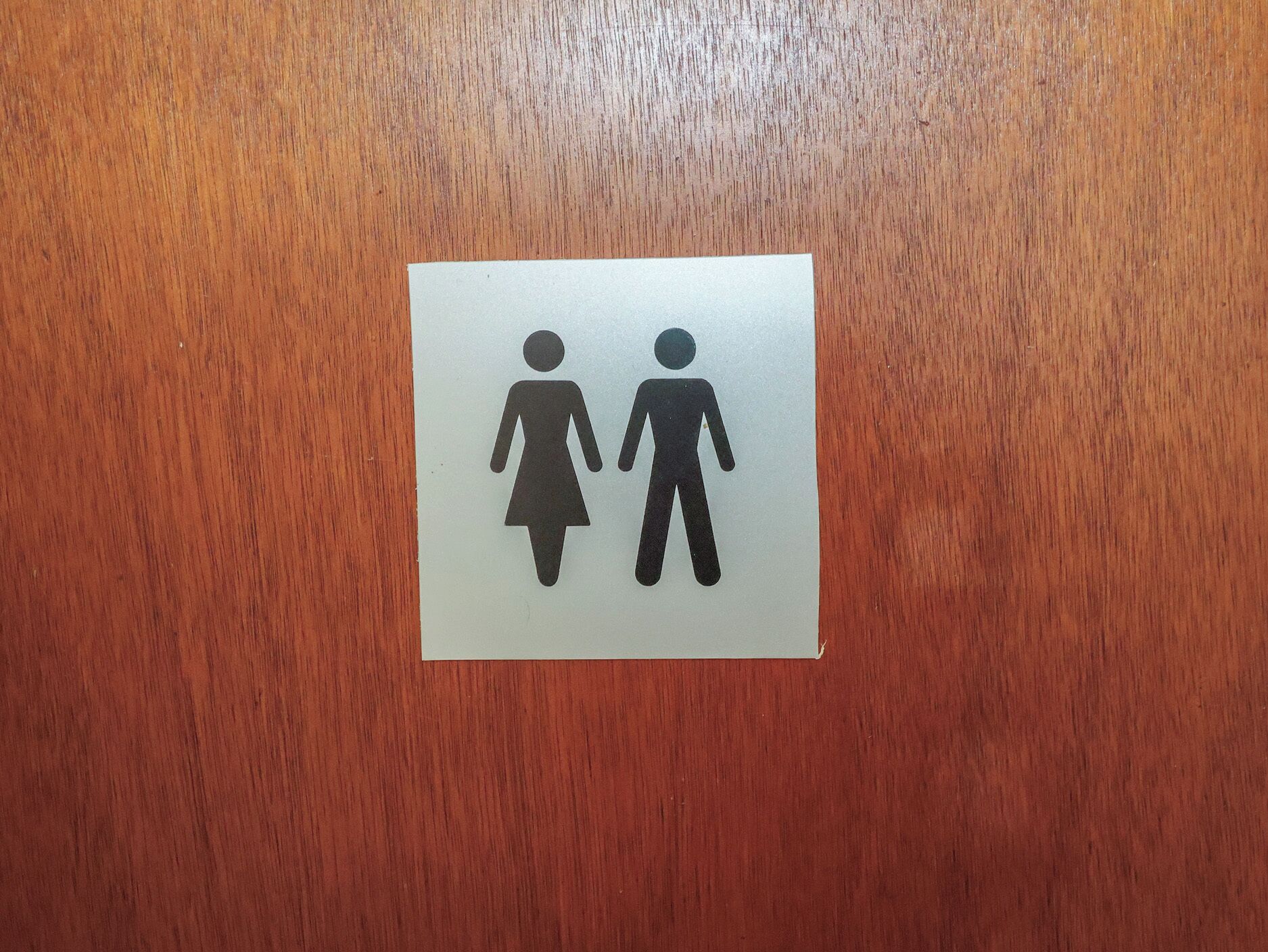A restroom sign with a male and female symbol.