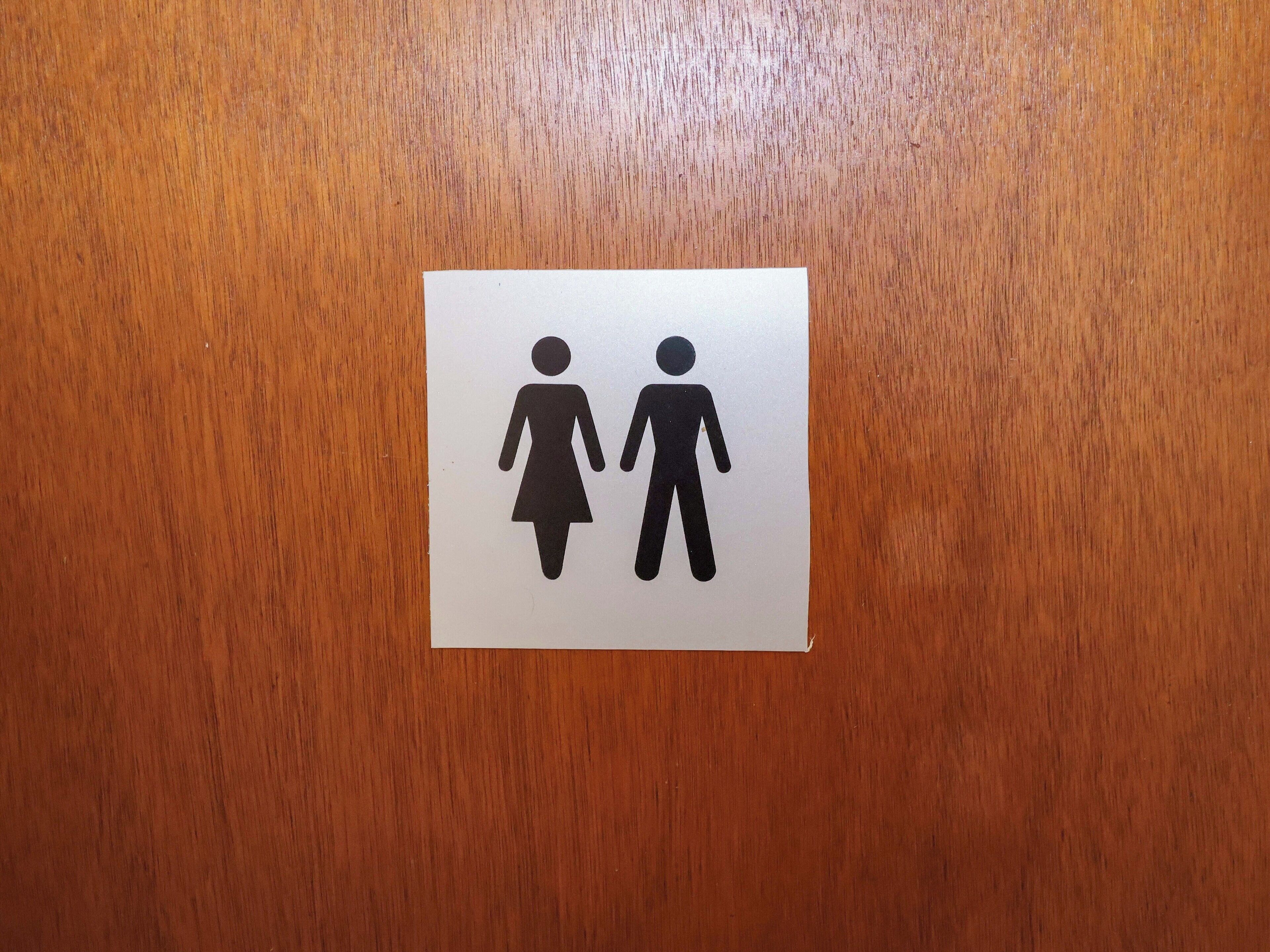 A restroom sign with a female and male figure symbol.