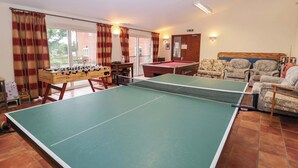 A room with a ping pong table, foosball table, and a pool table. - Churn House (Ipswich)