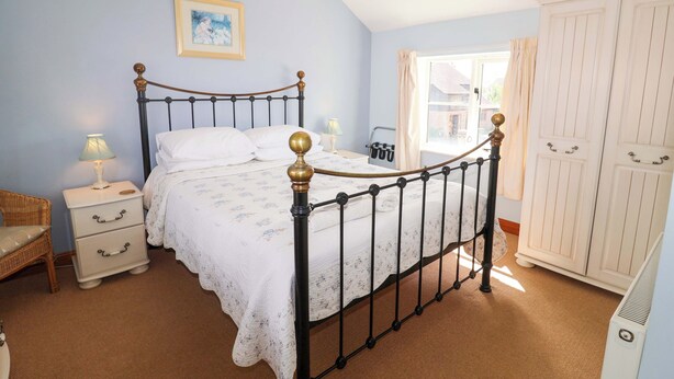 A bedroom with a bed, nightstand, dresser, and wardrobe. - Churn House (Ipswich)